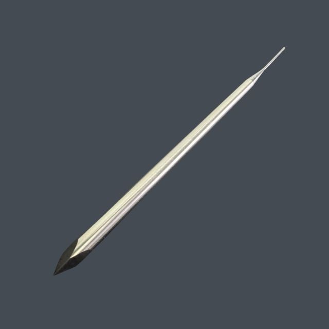 Long metallic needle with a sharp pointed tip on a gray background, angled diagonally downward left to right.